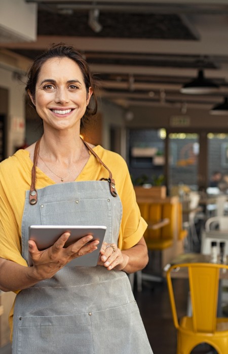 Mujer con delantal sujetando una tablet